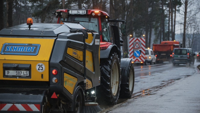 Traktors tīra ielu