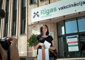 Sieviete ar ziediem un balvu