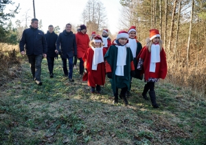 Cilvēki iet pa mežu
